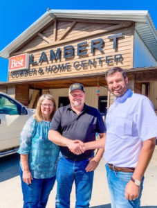 Chris Miller from Nation's Best shakes hands with owners of Lambert Lumber & Home Center