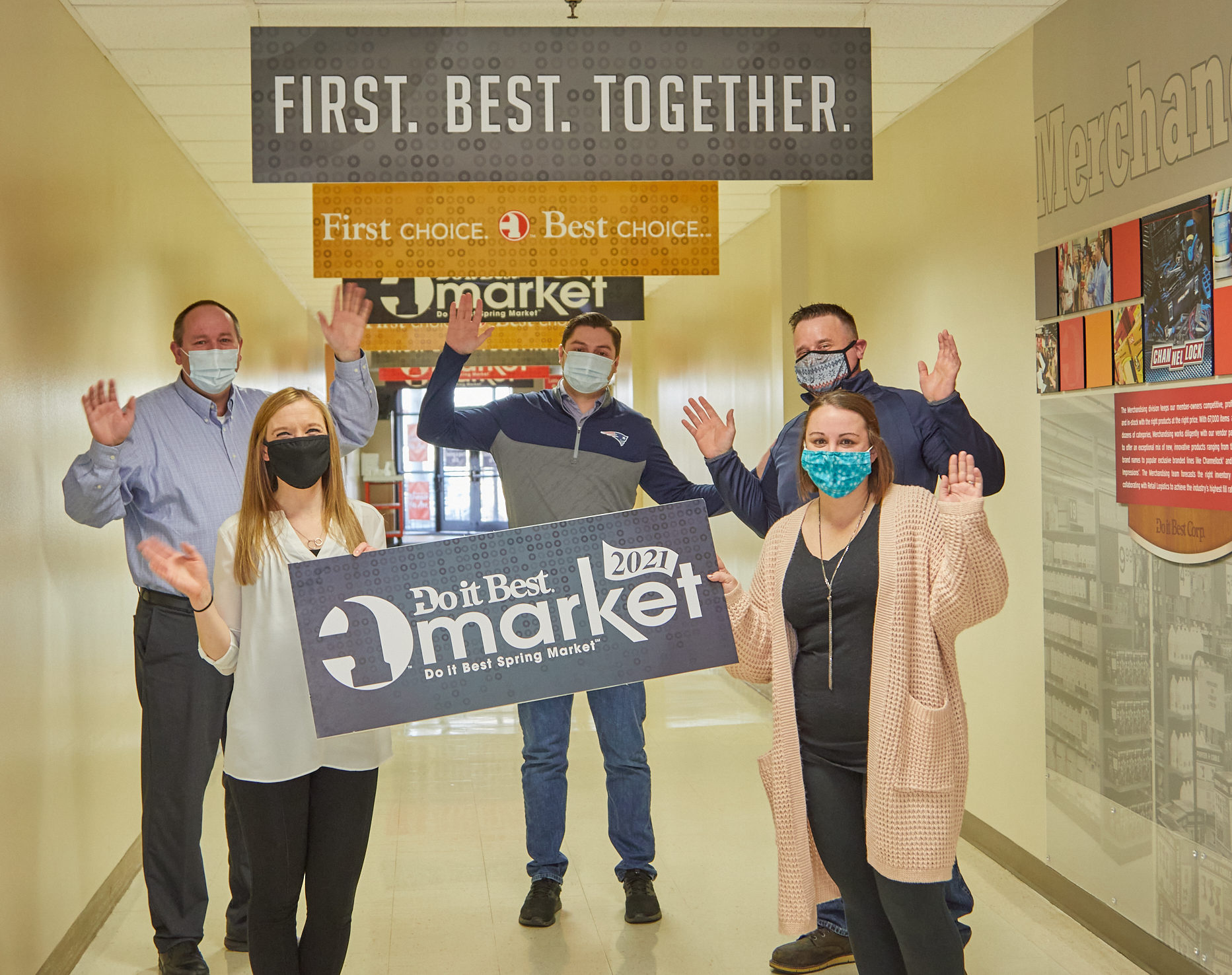 Do it Best staff holding signs promoting the 2021 Do it Best Spring Market